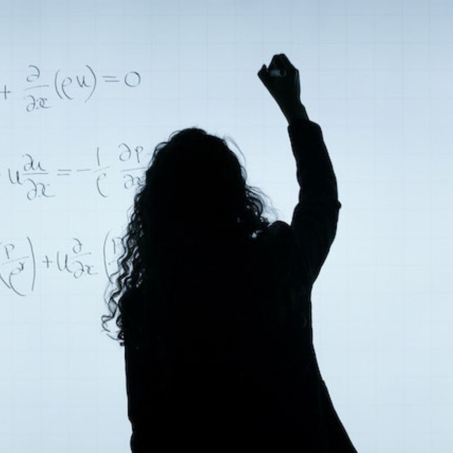a woman making calculations on a board